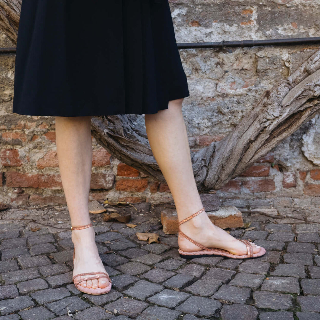 Woman wearing FAYE Antique Rosé Crystal Sandals by AERA, featuring vegan, sustainable, and designer crystal-embellished straps.